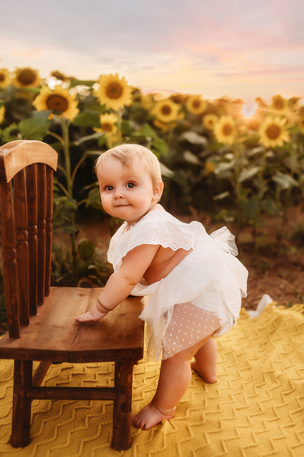 Baby looks at the camera during a Sunflower Field Photoshoot at Biltmore Estate in Asheville, NC.