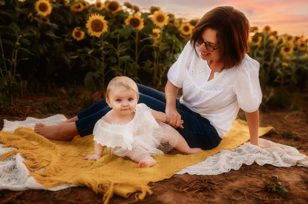 Mother plays with her baby during Sunflower Field Photos in Asheville at Biltmore Estate in Asheville, NC.