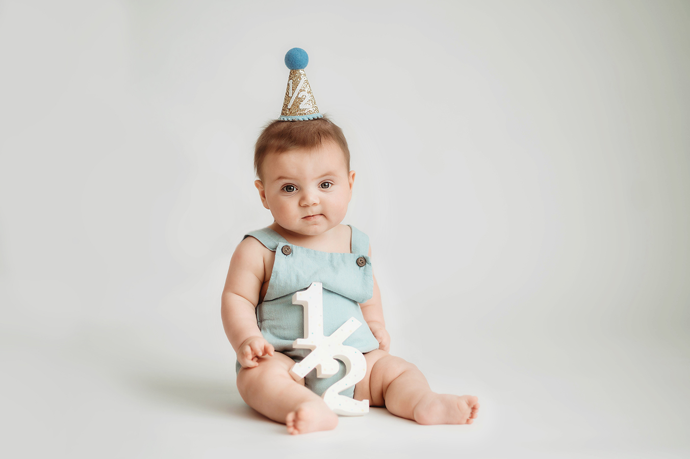 Baby poses for Birthday Cake Smash Portrait Session in Asheville, NC Photo Studio.