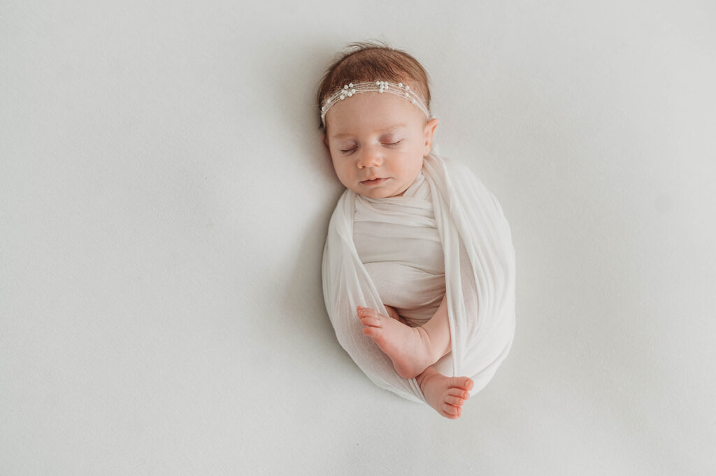Newborn Baby posed in an all white set during a Newborn Portrait Session in Asheville, NC.