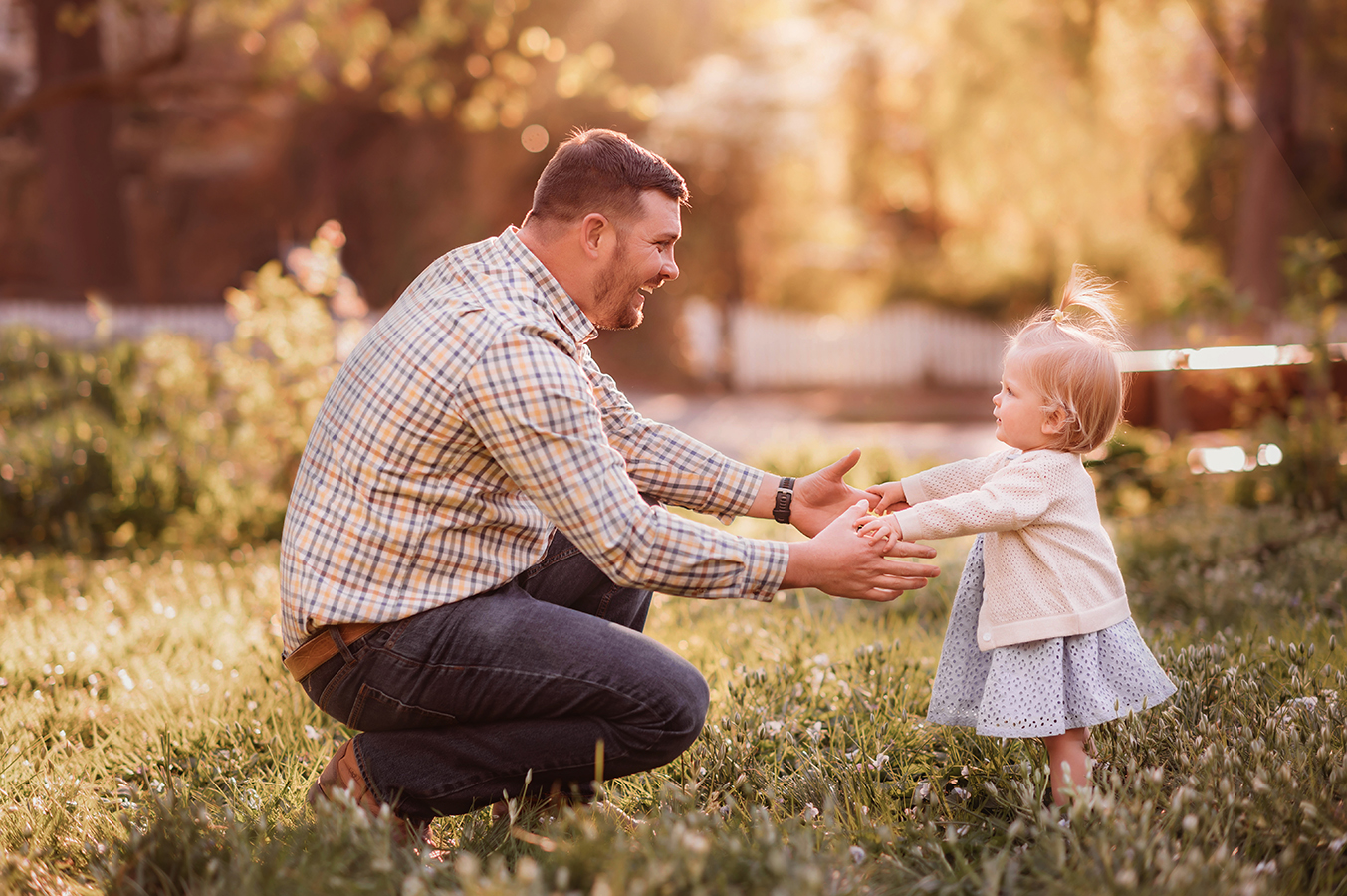 Father holds his daughter's hands in a beautiful meadow in Asheville, NC for Family Photoshoot.