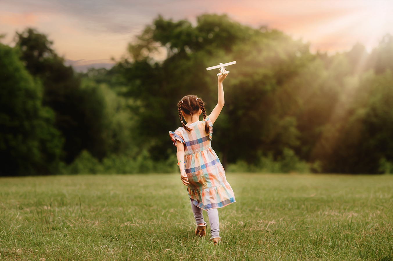 Little girl flies a plan in a field during her Family Portrait Session in Asheville, NC