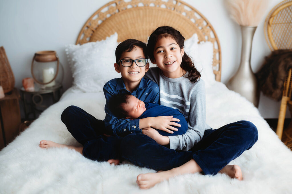 Newborn Baby posed with his siblings for Newborn Portrait Session at Asheville, NC Newborn Photography Studio.
