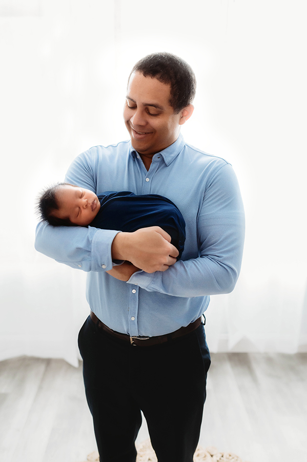 Newborn Baby posed with his father for his Newborn Portrait Session at Asheville, NC Newborn Photography Studio.