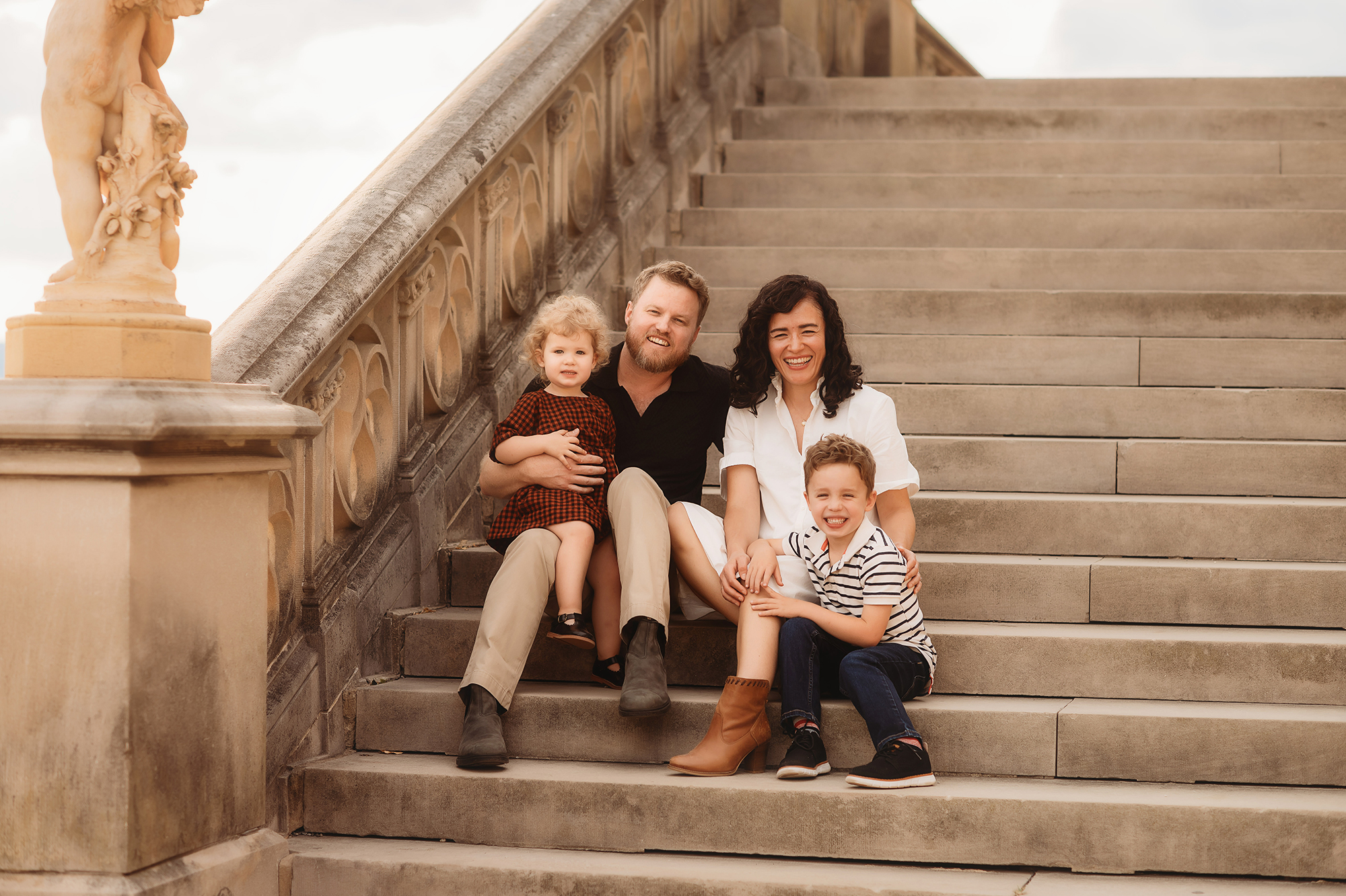 Family poses together on a beautiful staircase at Biltmore Estate for their Fall Family Photos in Asheville, NC.