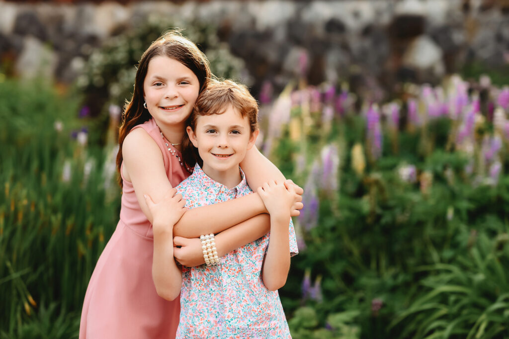 Siblings embrace in the garden during Family Photoshoot at Biltmore Estate in Asheville, NC. 