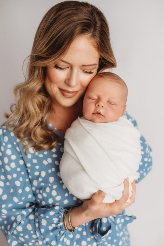 Asheville Newborn Photography Studio provides the Best Newborn Photos in Asheville. Portrait of a Mother holding her Newborn Baby boy during his Infant Photoshoot in Asheville.