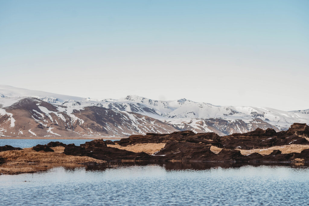 Landscape Photo of Snowy Mountains and Lava Fields Beach in Iceland.