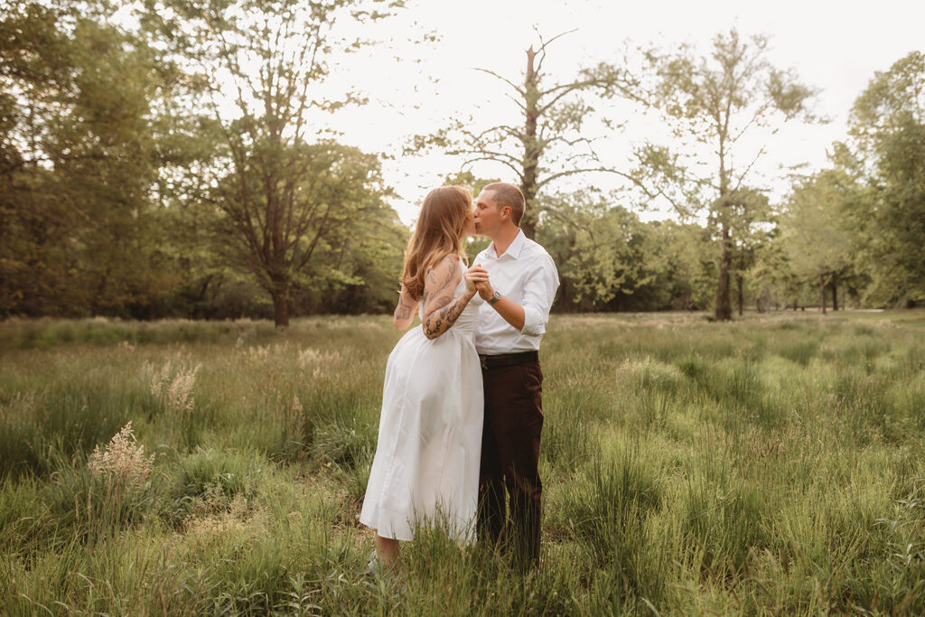 Newly Engaged Couple playfully dances in a field at Biltmore Estate during their Engagement Photos with Asheville Portrait Company in Asheville, NC