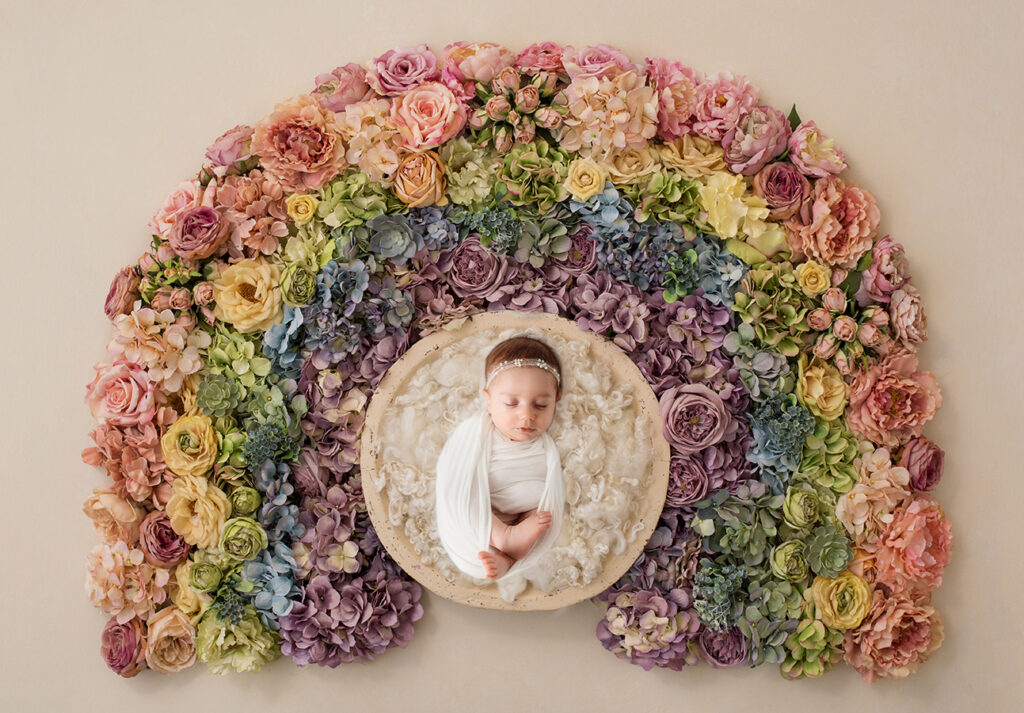 Newborn Baby posed in a floral rainbow set during Newborn Portrait Session in Asheville, NC.