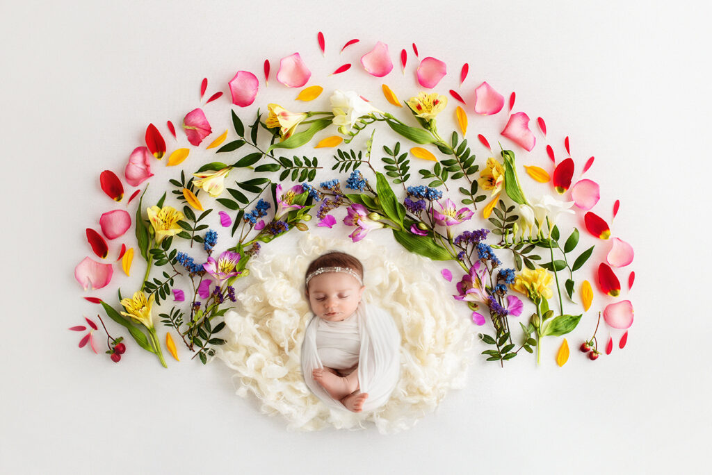Newborn Baby posed in a floral rainbow set during Newborn Portrait Session in Asheville, NC.